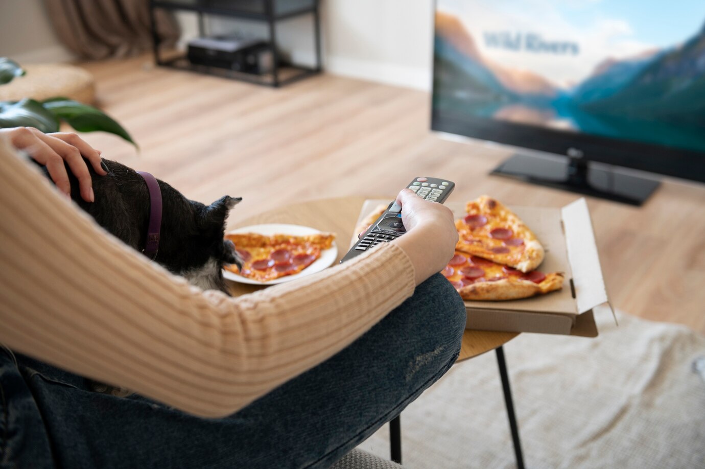 woman-eating-pizza-watching-tv_23-2149398047